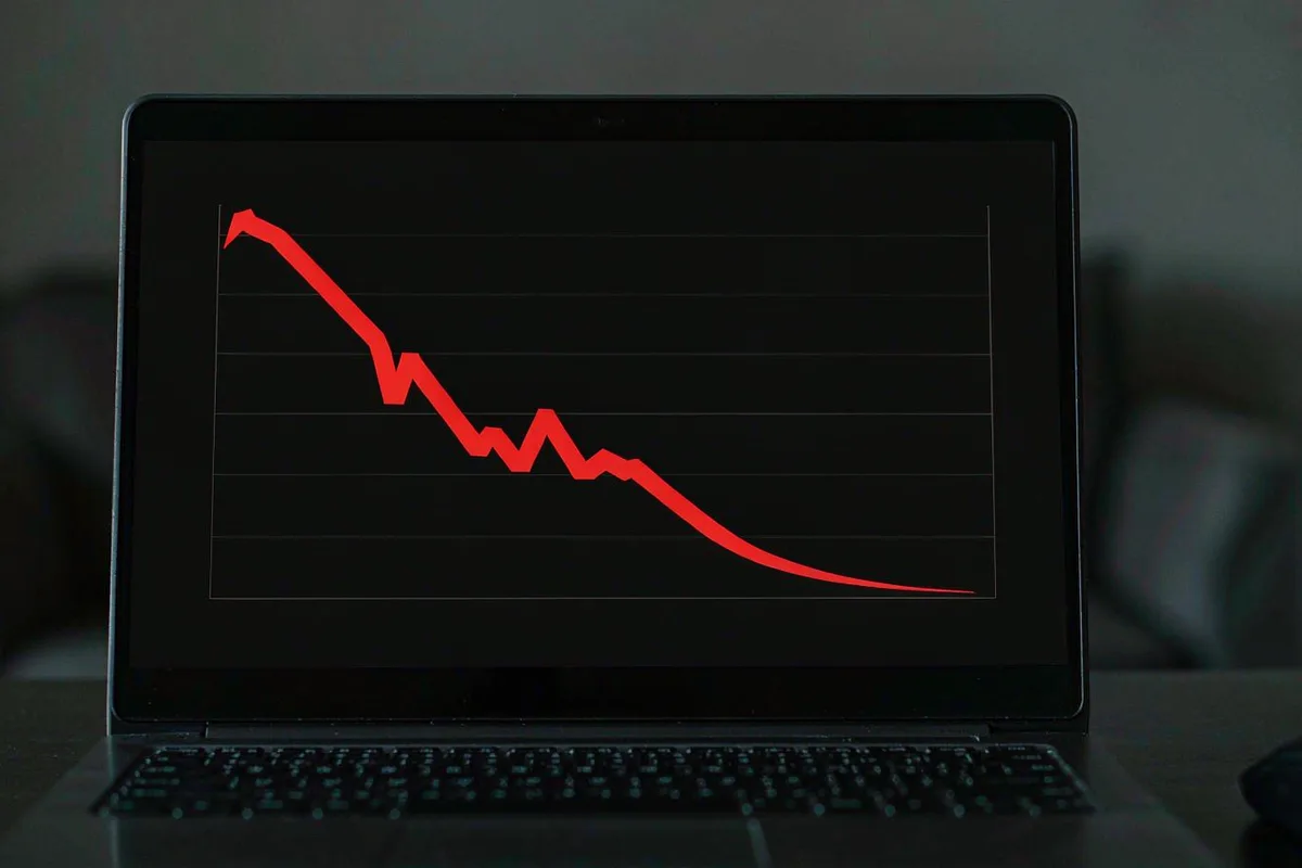 Laptop showing a red downward trending stock chart
