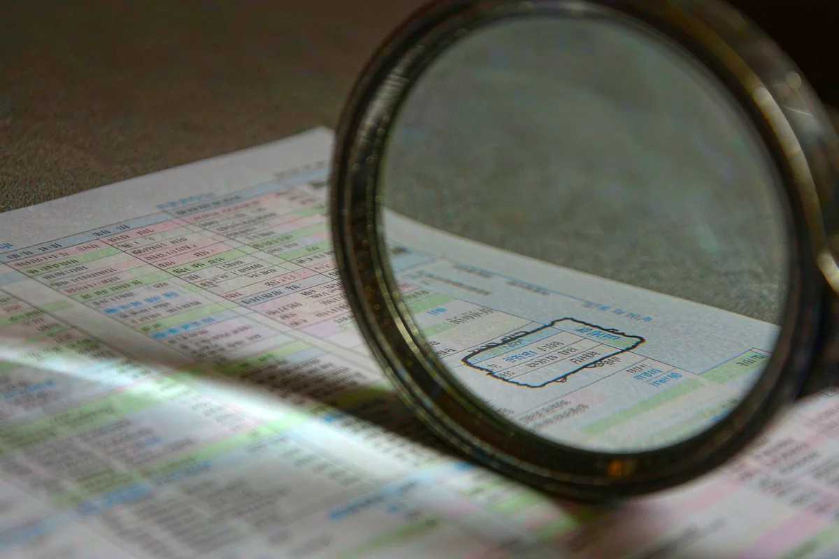 Magnifying glass held over a printed tax form