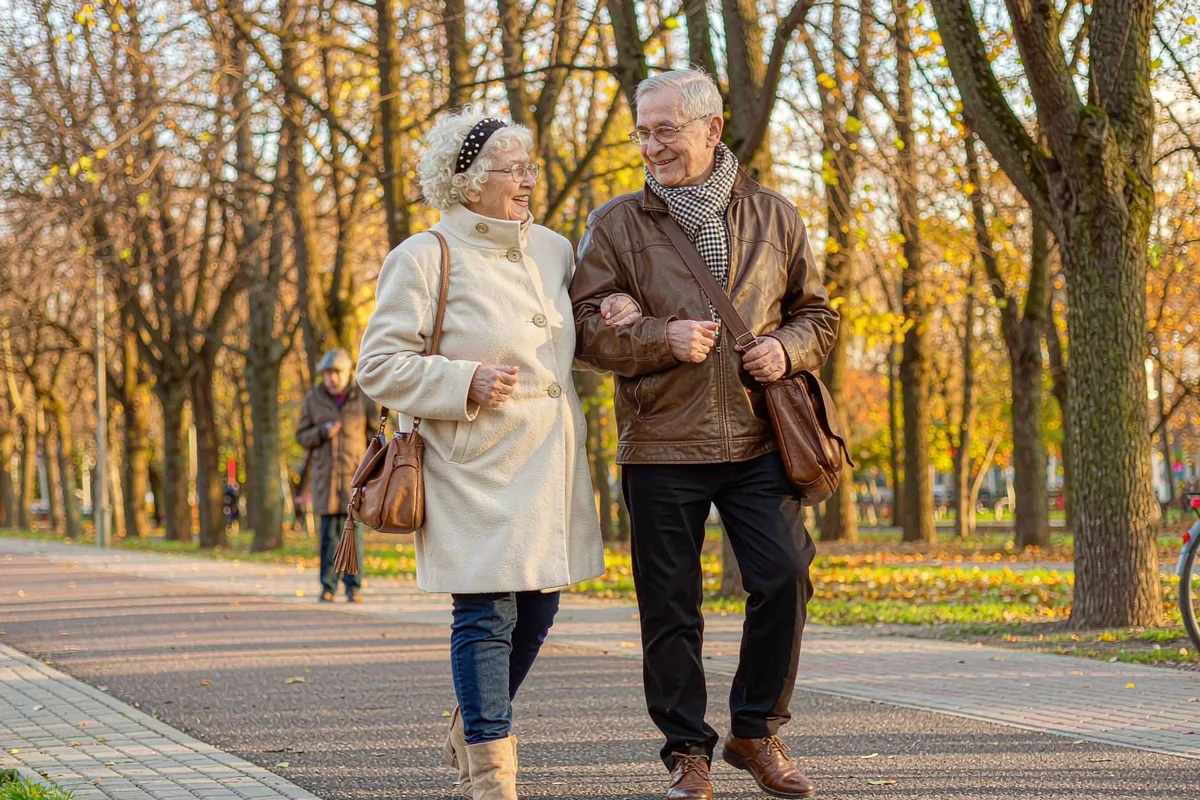 Senior couple holding hands on a tree-lined path